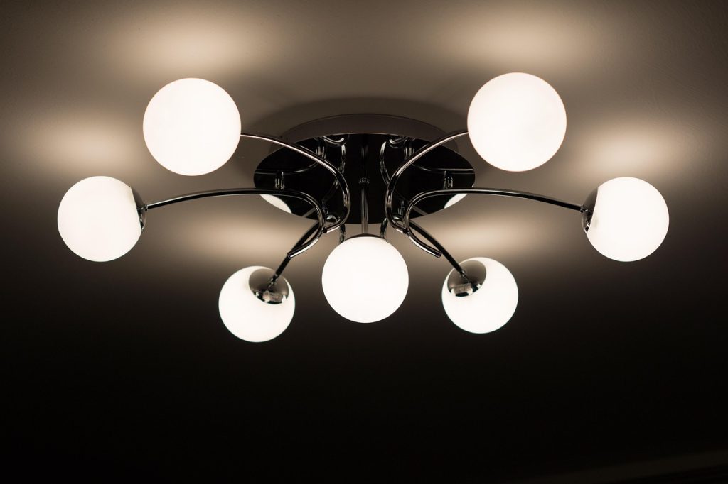 Nowoczesna sufitowa lampa z kilkoma kulistymi kloszami świecącymi ciepłym światłem