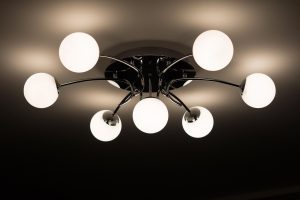Nowoczesna sufitowa lampa z kilkoma kulistymi kloszami świecącymi ciepłym światłem